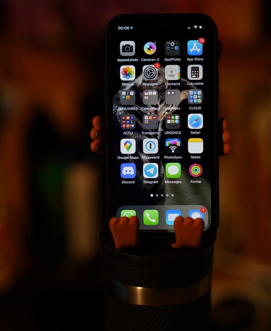 宅宅爱动漫 App 主界面示意，手机竖屏中展示作品卡片列表与顶部检索栏，浅紫银白配色，桌面木纹背景